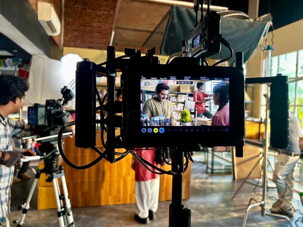 Professional ad shoot set with camera, lighting and production crew